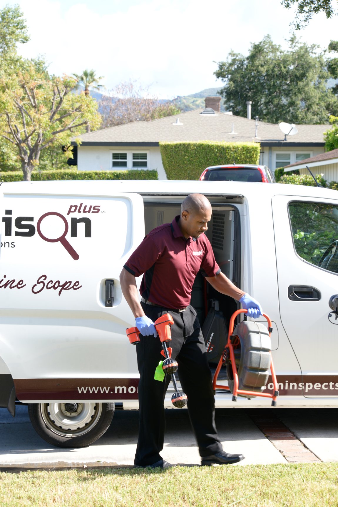 A Morrison Plus inspector with sewer line camera scoping equipment at a branded Line Scope van